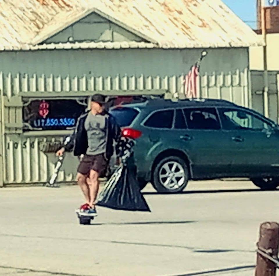 Jon Thomas Buck moving through Joplin while carrying a bag of collected litter